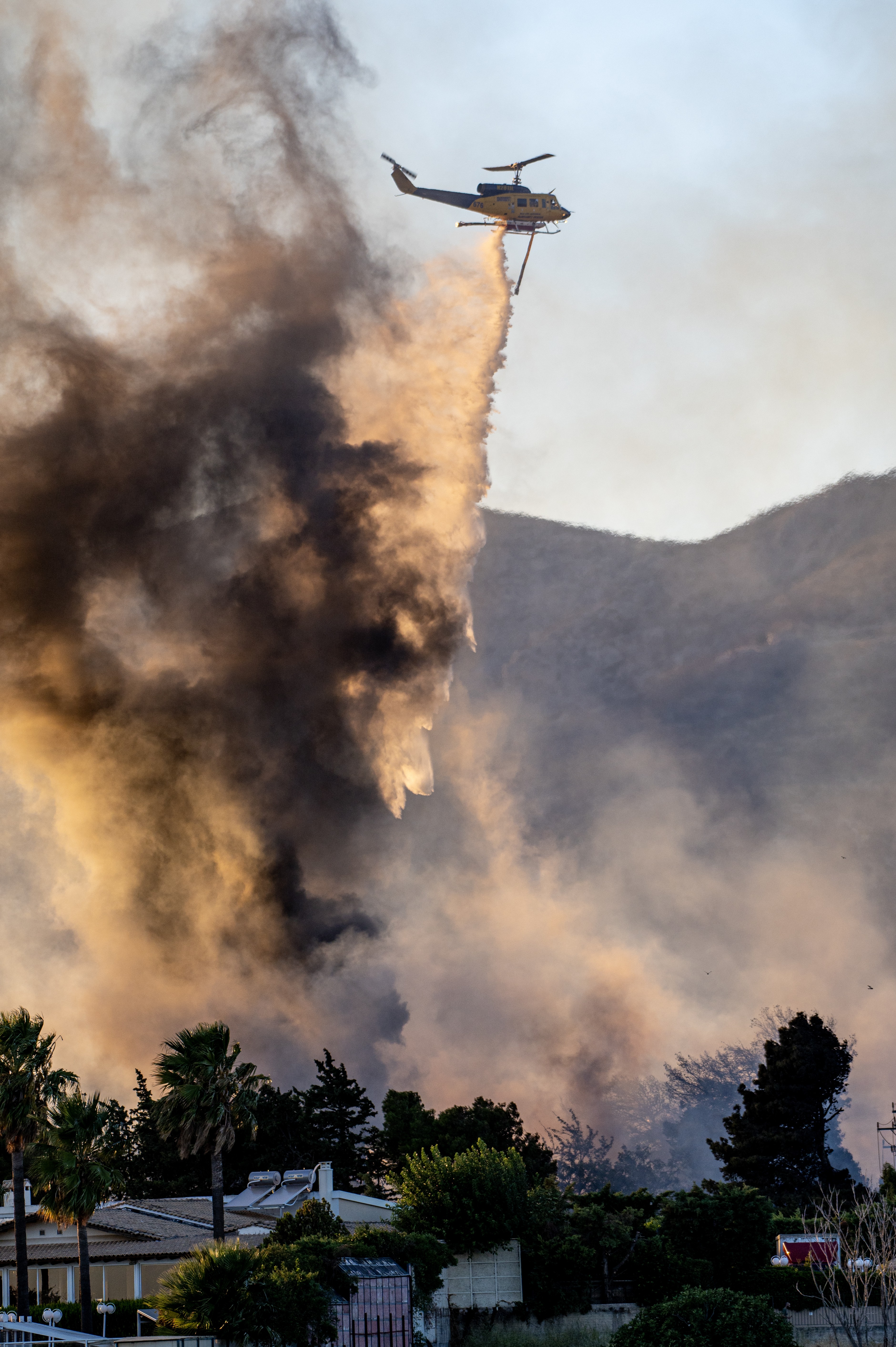 McDermott Bell 214B-1 working hard on a fire at a warehouse placed between houce's and others warehous's and small factories.