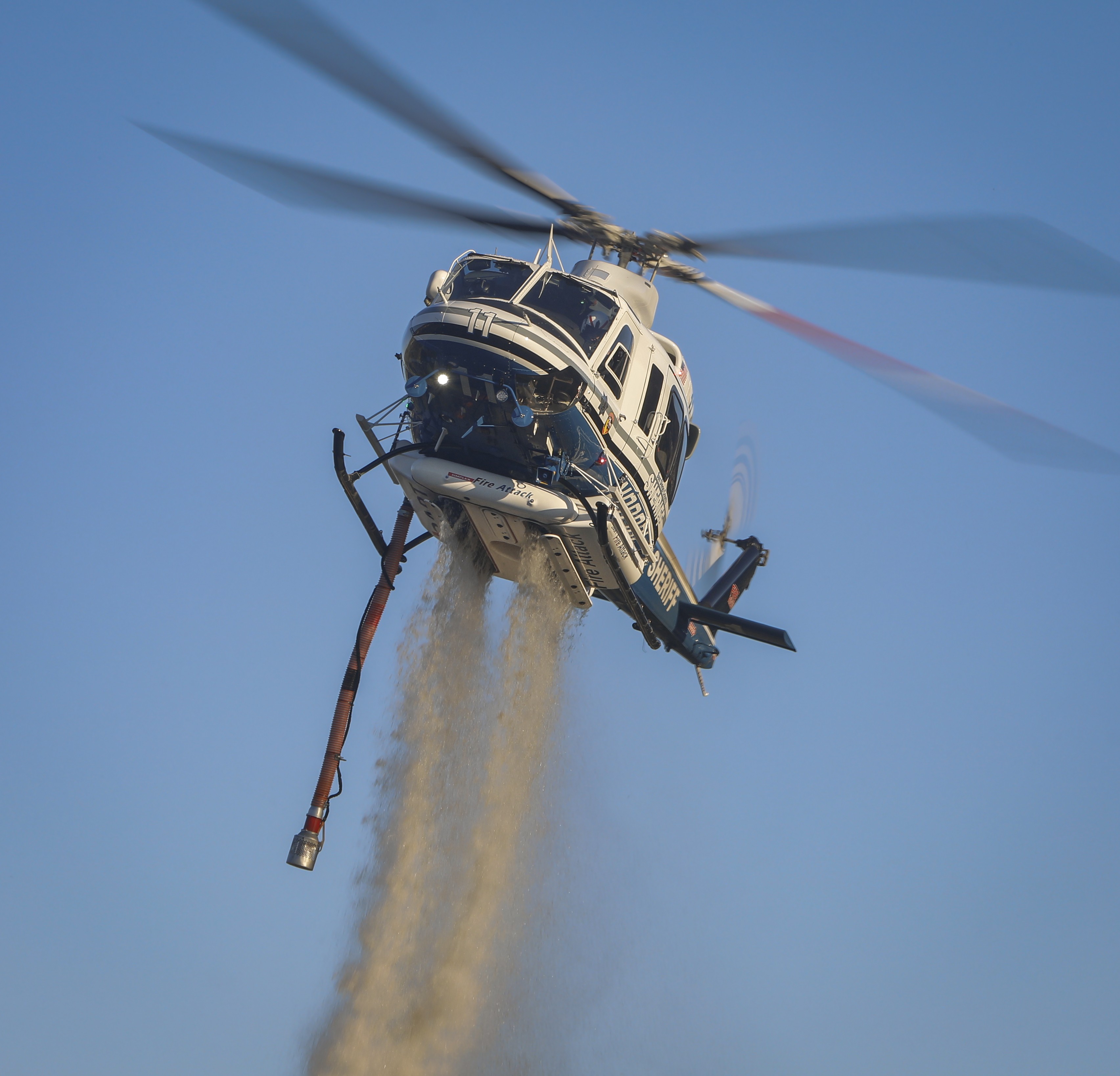 Copter 11 from the San Diego County Sheriff's Dept. dropping water during a small vegetation fire operation in the 4S Ranch area of San Diego, CA in October 2025.