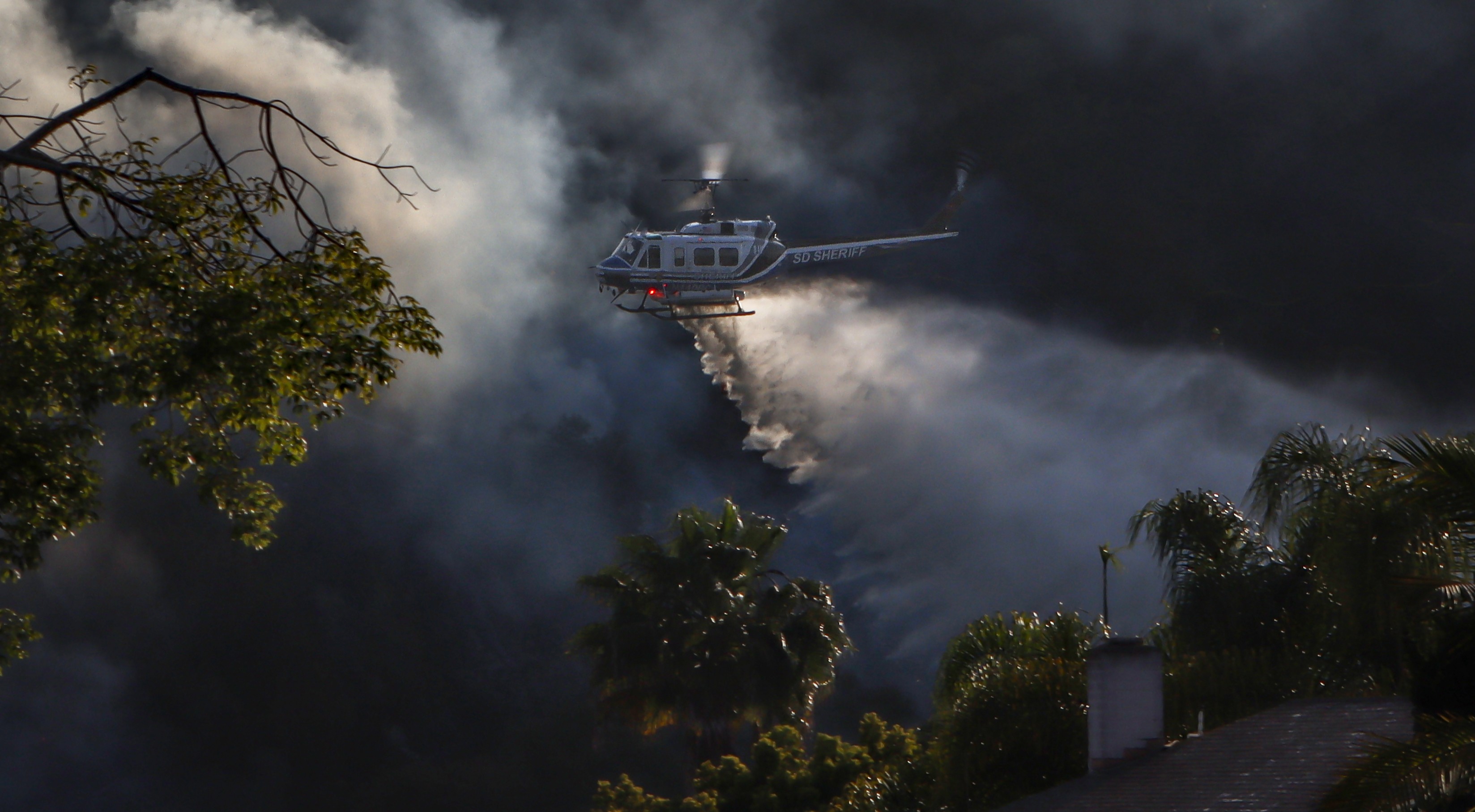 Copter 10 from the San Diego County Sheriff's Dept. actively battles a small vegetation fire in the Clairemont area of San Diego, CA during the Ariane Fire, June 2025.