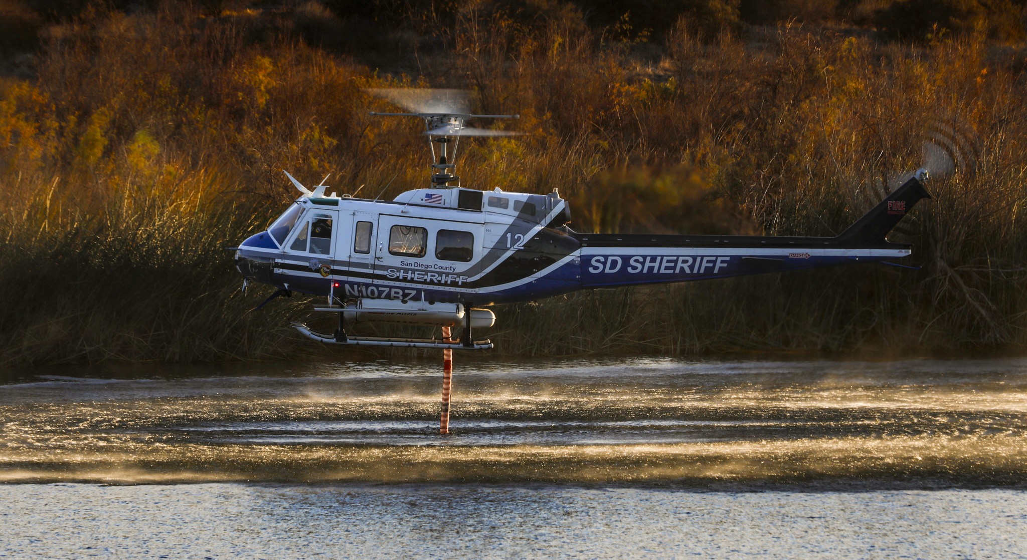 Copter 12 from the San Diego County Sheriff's Dept. holds a hover in the Otay Lakes dip during the Border 2 Fire in the Otay Mountains of San Diego County.