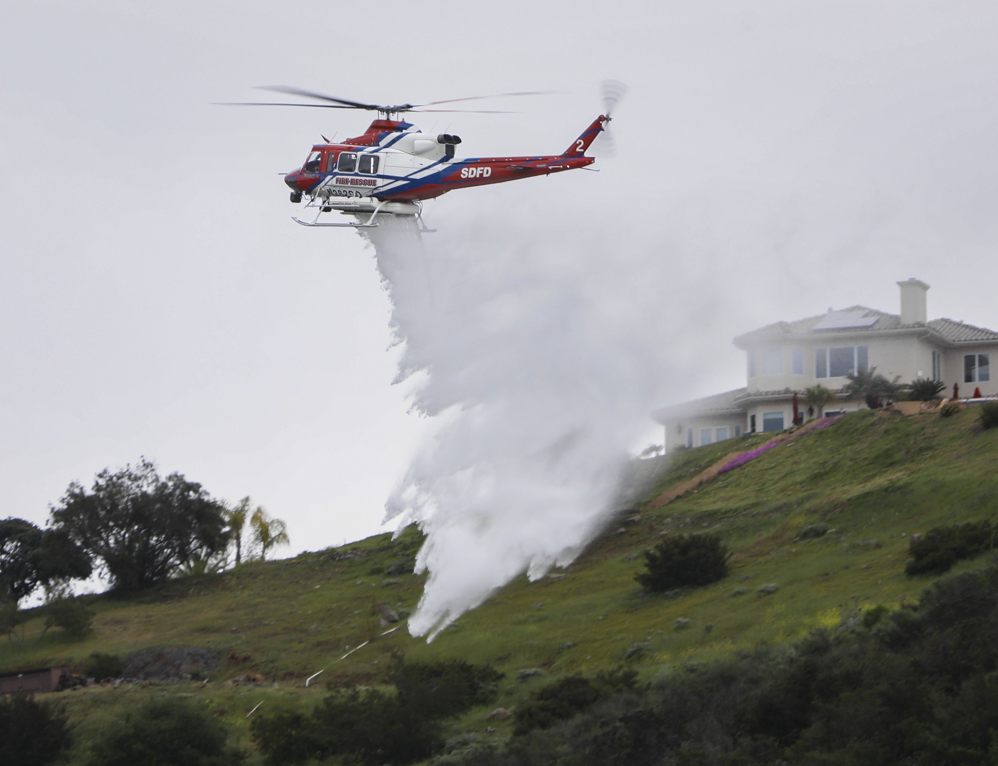 Copter 2 from the San Diego Fire-Rescue Air Operations Division, conducts water drops in the urban interface during a multi-agency training exercise in San Marcos, CA.