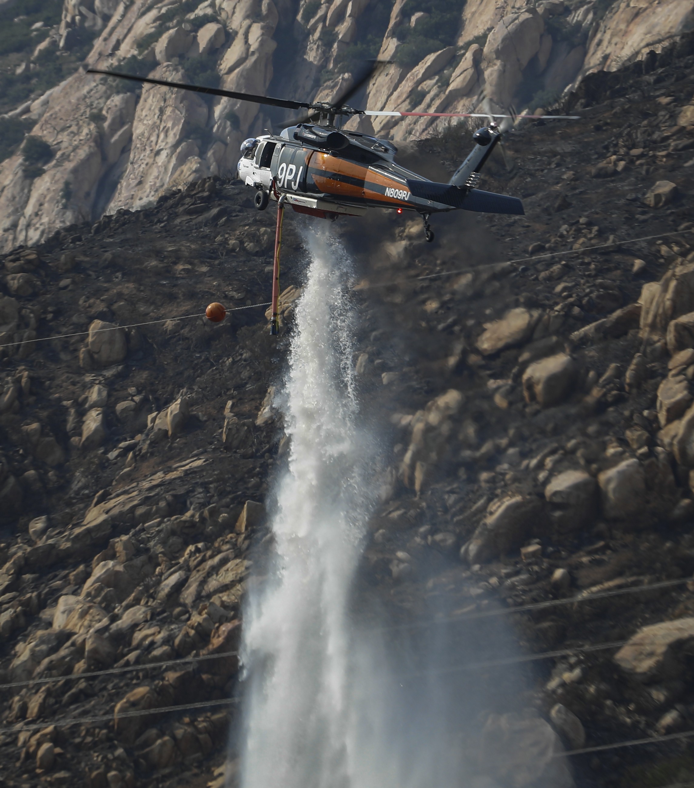 PJ Helicopters Copter 9PJ (a private contractor), assisting CAL FIRE San Diego with aerial fire suppression providing water drops and supporting firefighters on the ground during the Monte Fire.