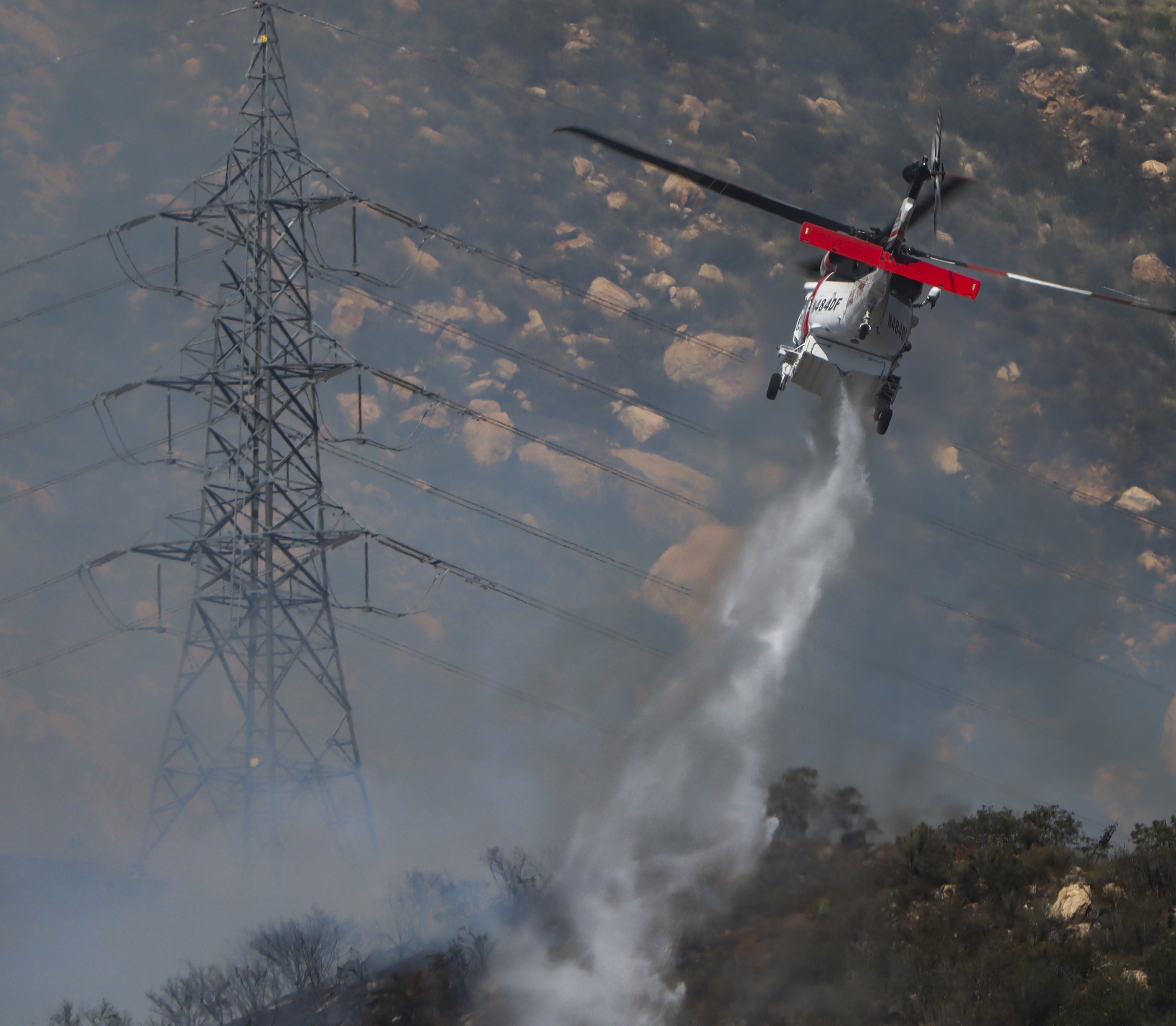 CAL FIRE Copter 609, fighting active flames in dense vegetation supporting other firefighting agencies with containing a large vegetation fire in Lakeside, CA dubbed the Monte Fire.