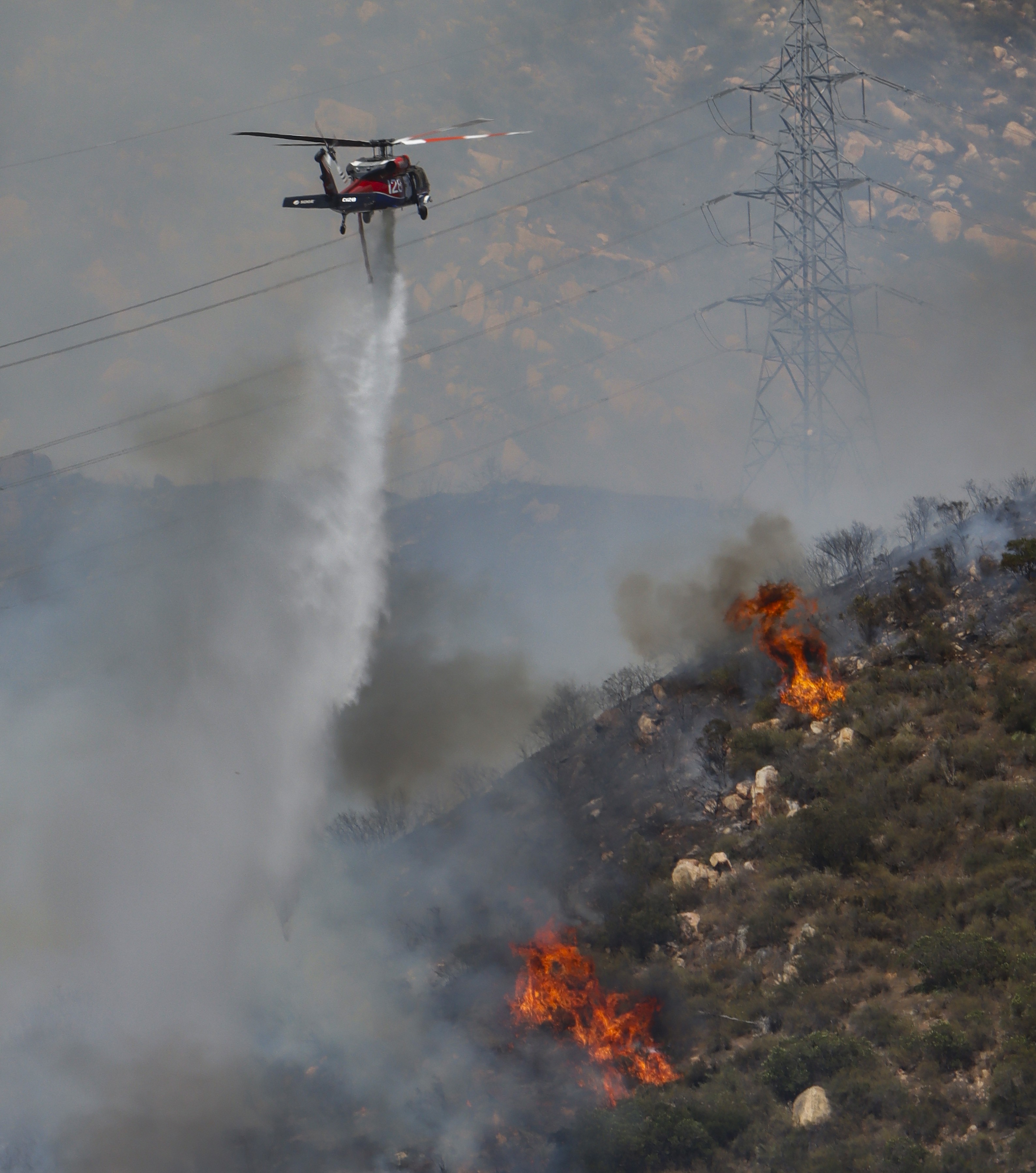 Copter 128, making water drops on active flames in dense vegetation while supporting other firefighting agencies on containing a large vegetation fire in Lakeside, CA dubbed the Monte Fire.