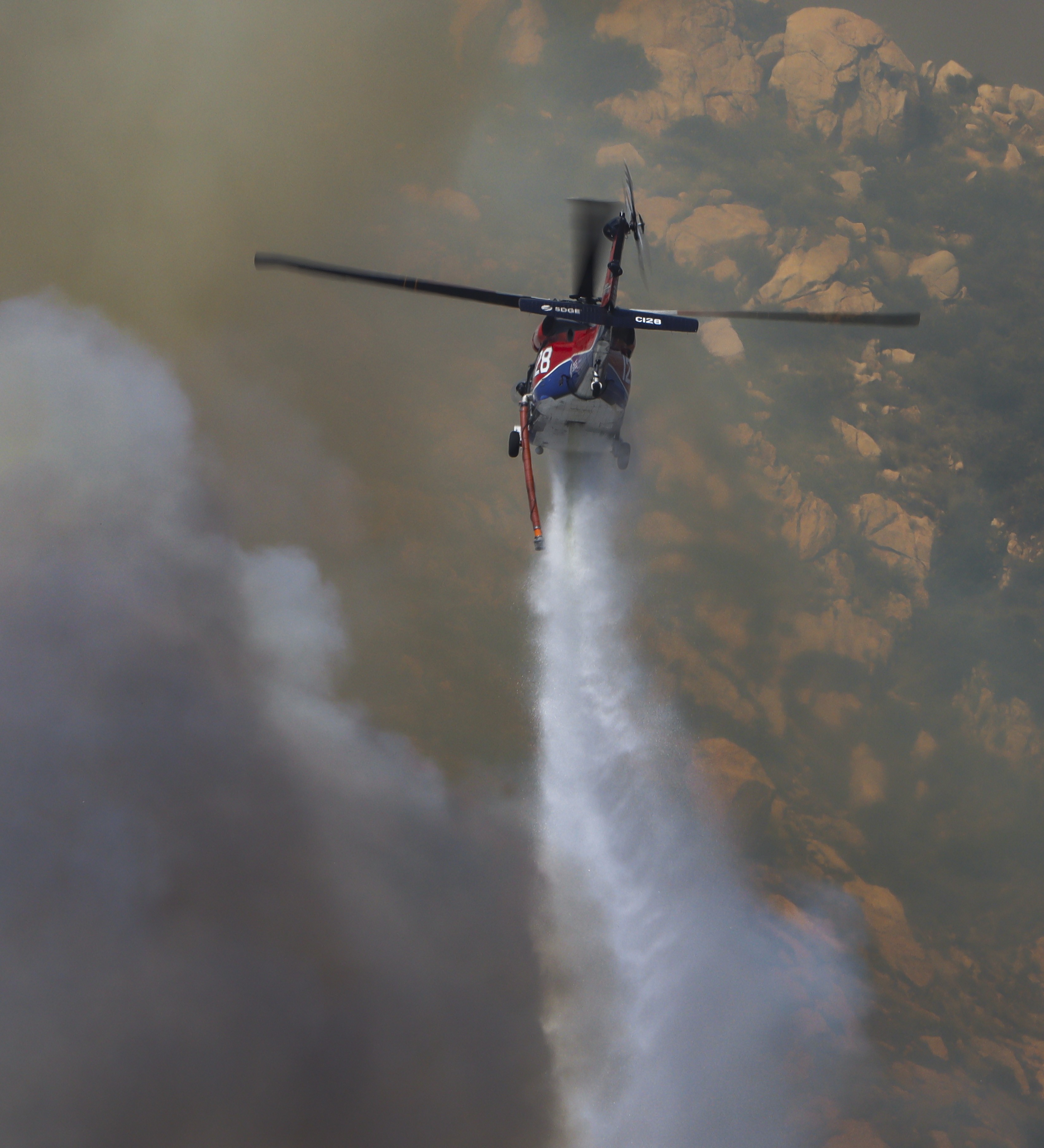 Copter 128, making water drops on spot fires in dense vegetation while supporting other firefighting agencies on containing a large vegetation fire in Lakeside, CA dubbed the Monte Fire.