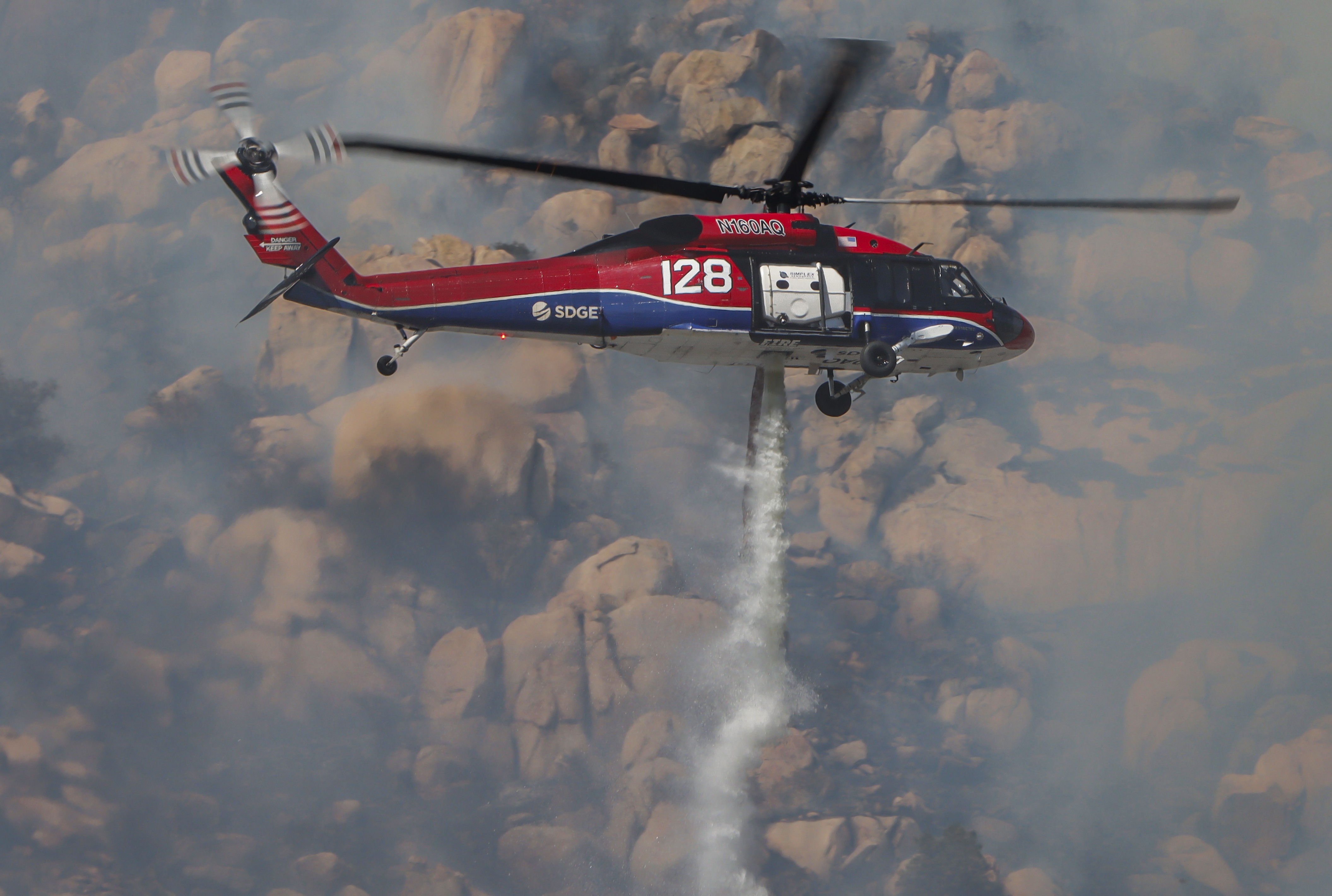 Copter 128, making water drops on spot fires in dense vegetation while supporting other firefighting agencies on containing a large vegetation fire in Lakeside, CA dubbed the Monte Fire.