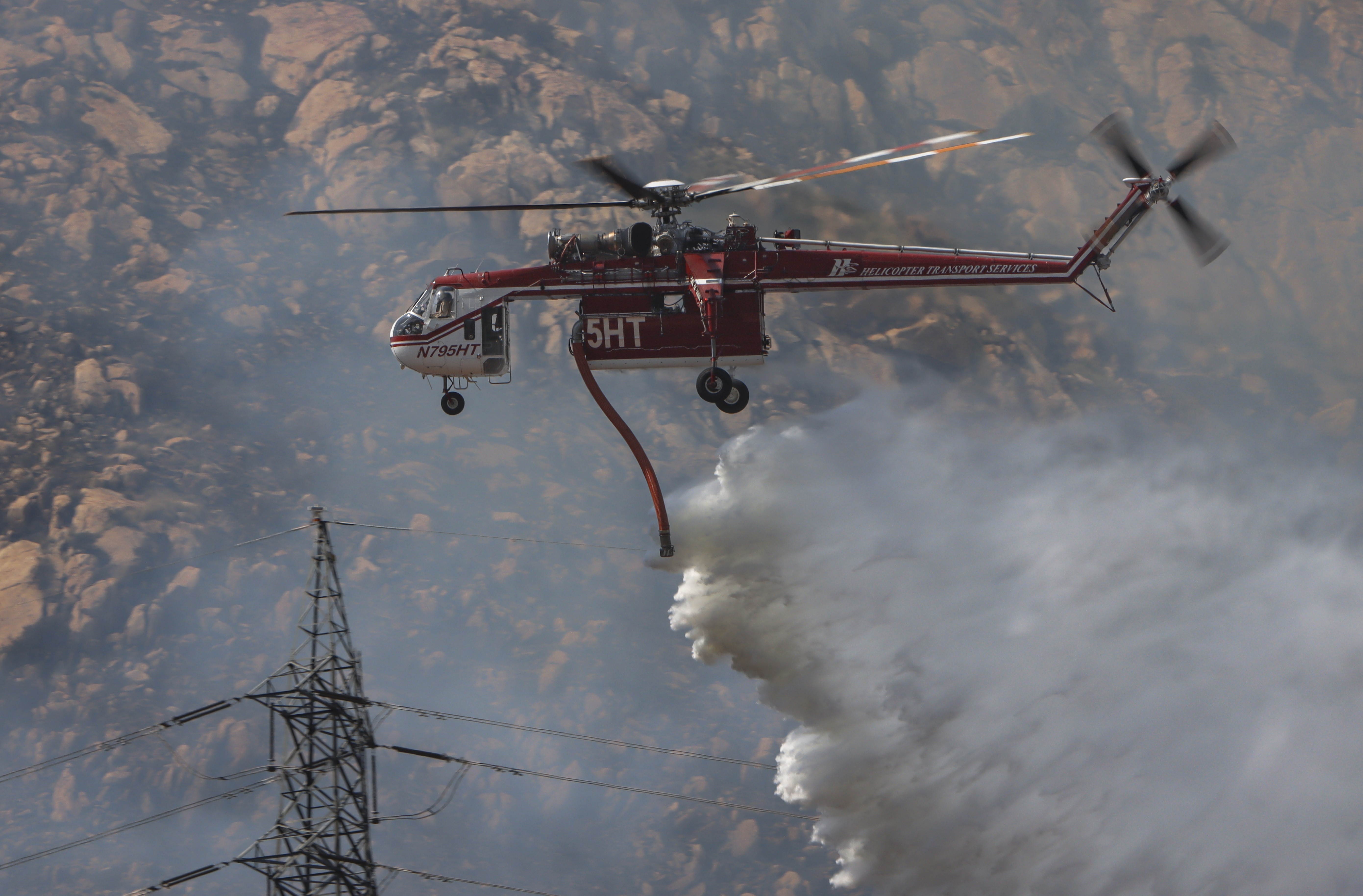 Helicopter Transport Services (HTS) Helitanker 5HT, dropping water while supporting other firefighting agencies on containing a large vegetation fire in Lakeside, CA dubbed the Monte Fire.
