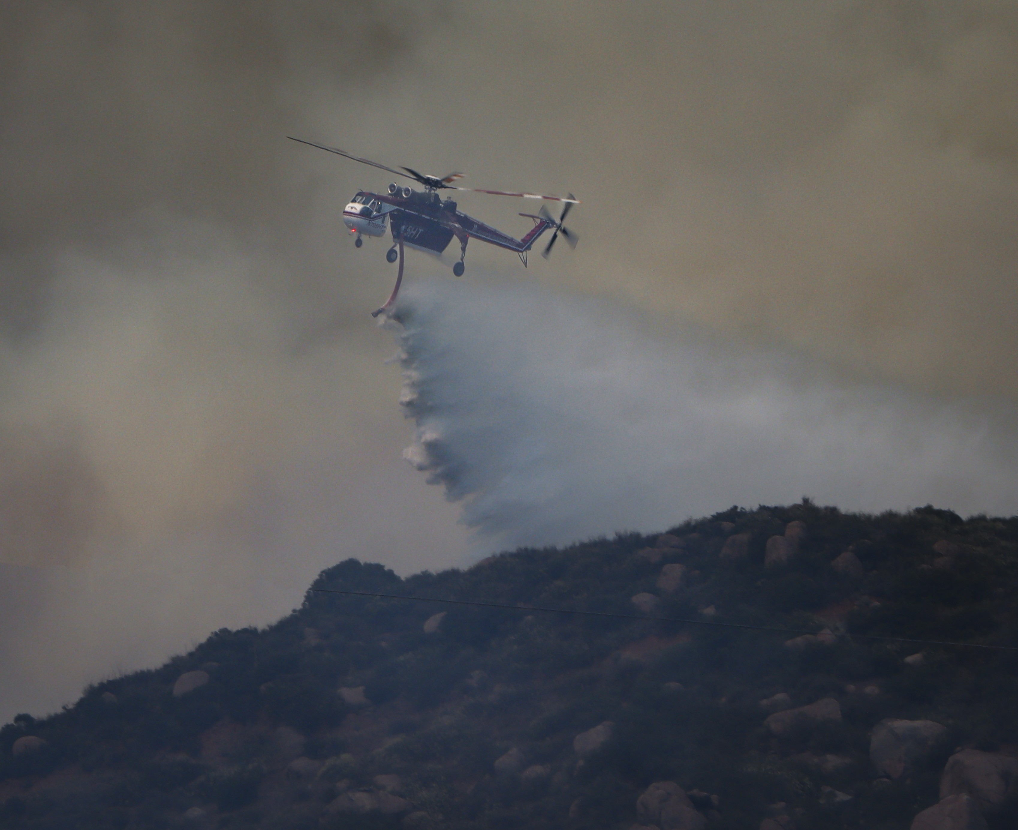 Helicopter Transport Services (HTS) Helitanker 5HT, dropping water while supporting other firefighting agencies on containing a large vegetation fire in Lakeside, CA dubbed the Monte Fire.