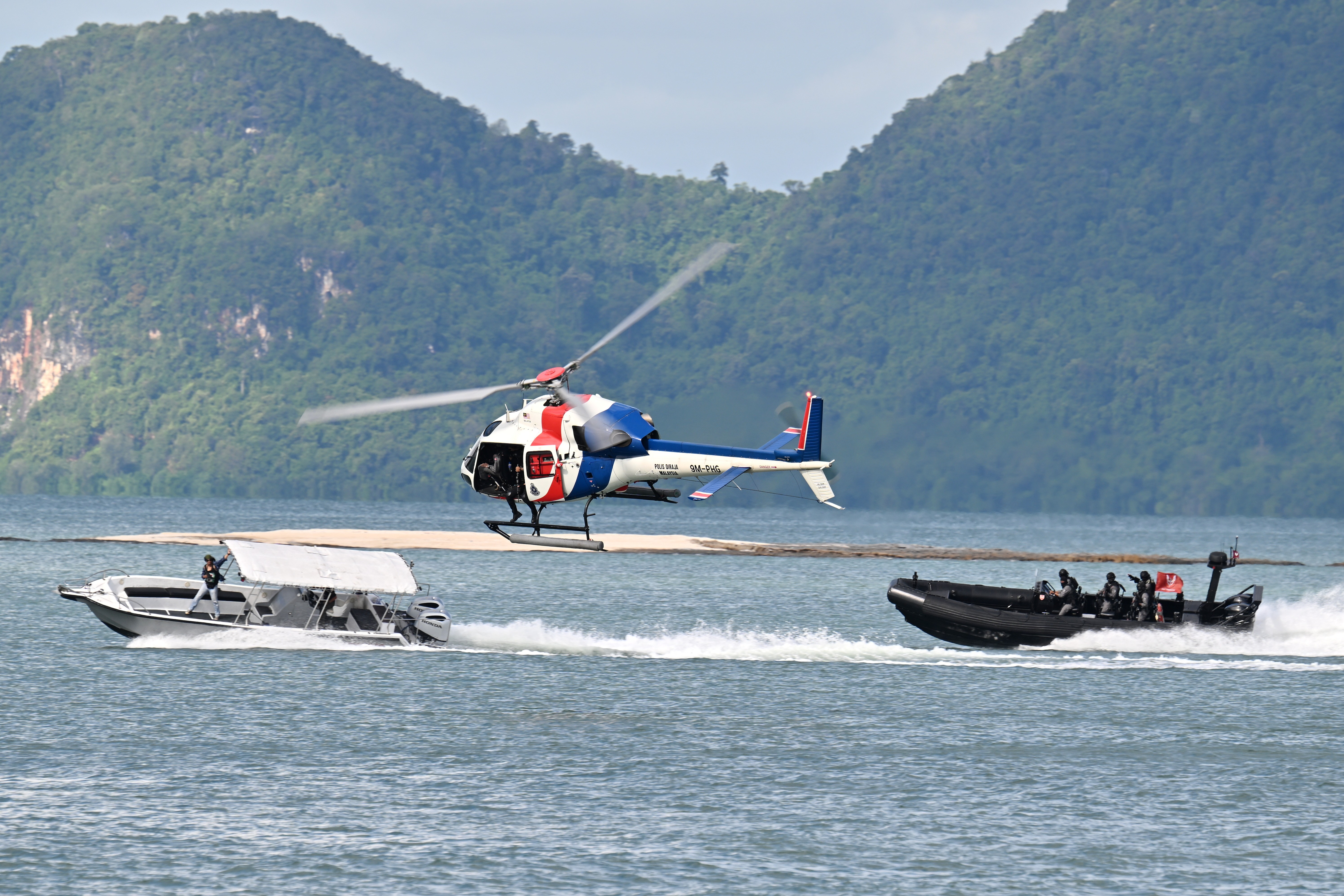 This AS355N 9M-PHC of Polis Diraja Malaysia is demostrating a boat terrorist chase during the maritime display at Langkawi Resort World during LIMA 2025 Aerospace Exhibition